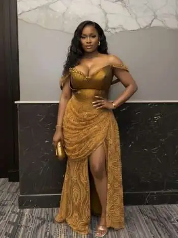 Full-body front view of gold beaded mermaid wedding dress with corset bodice, draped lace detail and thigh-high slit — Akugo Gold Gown by Chimzi Couture.